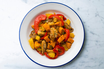 Stir-fried chicken with sweet potato and red pepper. Top view table with  decorations.