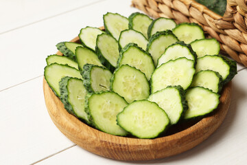 Slices of fresh cucumbers on white wooden table