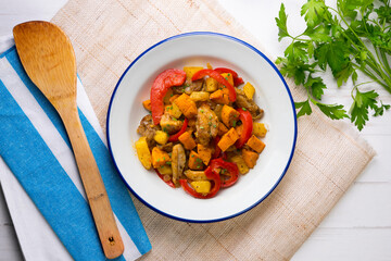 Stir-fried chicken with sweet potato and red pepper. Top view table with  decorations.
