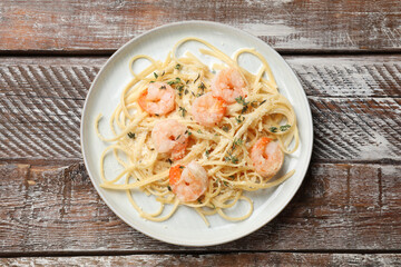 Delicious pasta with shrimps on wooden table, top view