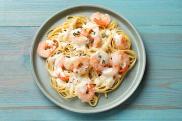 Delicious pasta with shrimps on blue wooden table, top view
