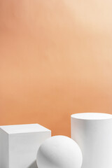 White geometric shapes arranged stylishly on a soft peach background in a minimalist setting