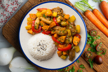 Stir-fried chicken with sweet potato and red pepper. Top view table with  decorations.