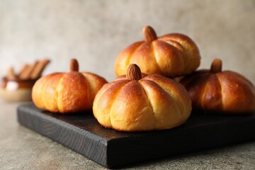 Tasty pumpkin shaped buns on grey table, closeup