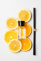 Aromatic display of essential oils with citrus fruit and chopsticks on a minimalist background