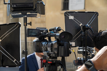 reporter de t&eacute;l&eacute;vision devant une cam&eacute;ra dans la rue