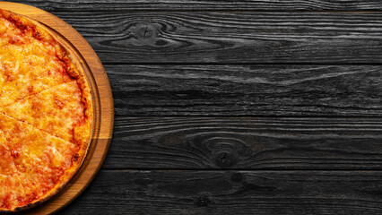 pizza margherita on black wooden table, top view, pizzeria concept