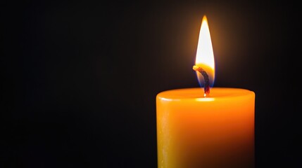 Close-up of a single candle flame against a black background, evoking a sense of warmth, peace, and serenity in a minimalist scene.