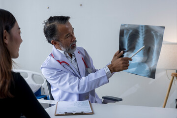 Doctor showing x-ray of lungs to a female patient in medical office