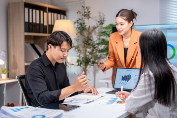 Business team analyzing financial charts and graphs on laptop in office meeting