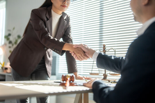 Lawyers shaking hands after successful business deal in law office - Powered by Adobe