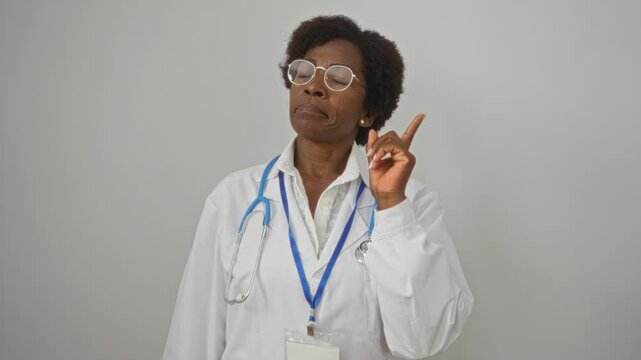 Female doctor with curly hair and glasses giving advice in a white lab coat, standing against an isolated white background