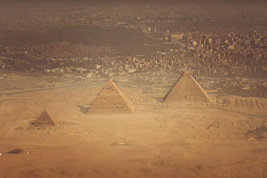The aerial panorama view of Egyptian pyramids of Giza, with Giza town and Cairo city districts is seen in the background.

