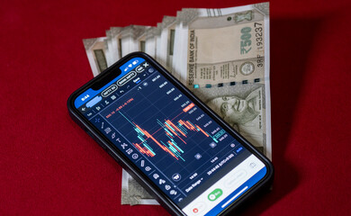 Indian 500 rupee currency bank note against share market chart on a display