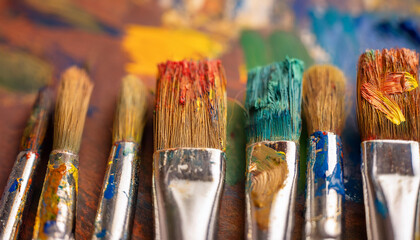 Fototapeta premium Well-used paint brushes with traces of colorful paint. Wet paint. Hobby and leisure concept.