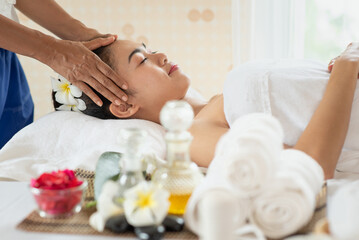 Young Asian woman getting massage in the spa salon, enjoying and relaxing