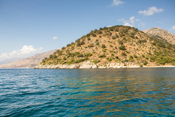 Fototapeta premium Very beautiful coastline on the Ionian Sea in Albania. The beach with fine sand in the mountains of Albania. Vacation at the sea.