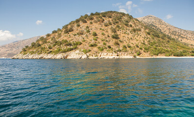 Very beautiful coastline on the Ionian Sea in Albania. The beach with fine sand in the mountains of Albania. Vacation at the sea.