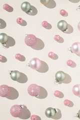 Pastel christmas ornaments on cream background. Aesthetic decoration concept.