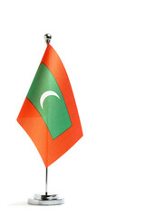 Table national flag Maldives on metal flagpole on white background.