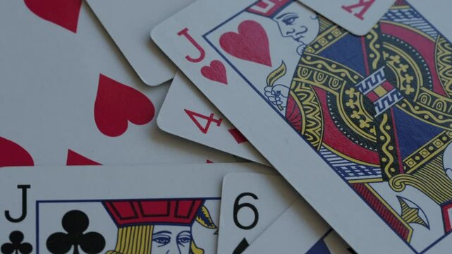 Pile of playing cards background rotating macro video. Shuffled suits and numbers. Gambling and casino concept.	