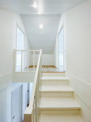 Imagine a long, spacious hallway featuring a stunning staircase that leads to the second floor, exuding elegance and showcasing intricate design details of this remarkable building