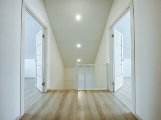 Fototapeta premium A beautifully designed hallway with polished wooden floors and elegant glass doorways reflects natural light, creating a spacious and inviting atmosphere for all who enter