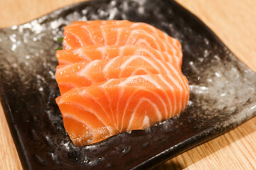 close up of Japanese salmon fish sashimi on a black plate