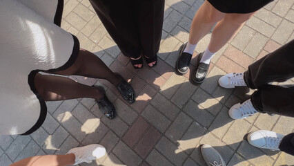 Group of people standing on pavement wearing stylish shoes