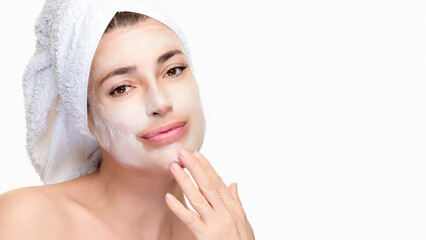 Woman enjoying skincare routine with facial mask and towel