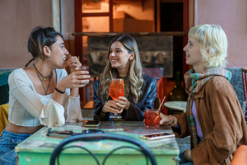 Young diverse women friends celebrating at trendy cafe, social lifestyle gathering