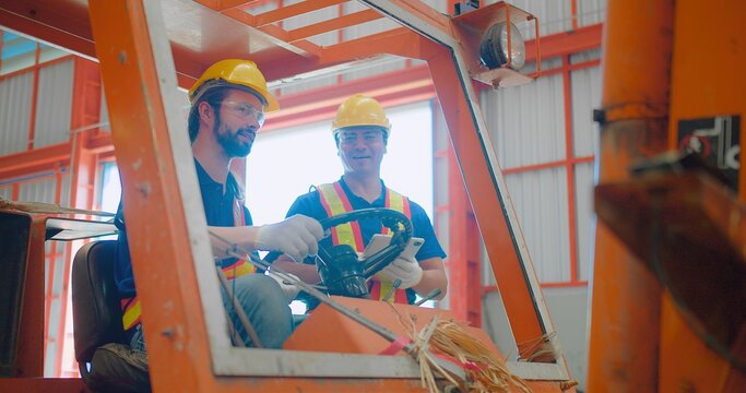 Construction workers engineers in yellow hard hats and safety vests are discussing operate a construction lift machinery within an industrial environment, focus on occupational safety and teamwork