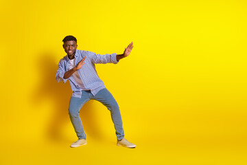 Full length photo of handsome good mood guy wear plaid shirt practicing karate emtpy space isolated yellow color background