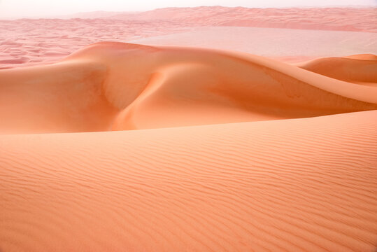 Reddish sand dunes in the Tal Moreeb desert in Liwa, Abu Dhabi, U.A.E.  