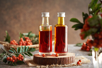 Two glass bottles of herbal syrup made of wild rowanberry fruit