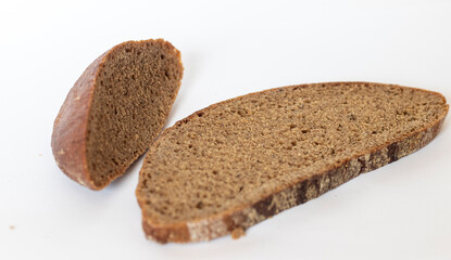Close up shot of pieces of brown bread on white background. Food