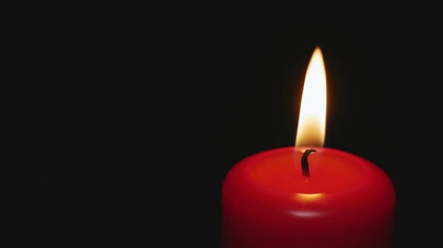 Red candle on a dark background burns in memory of the dead people who died in the war, from diseases. Place for the text. Memorial Day, Veterans Day