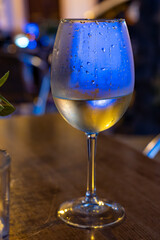 Glass of cold dry white wine served outdoor in cafe at night in historical Triana district, Sevilla, Spain, close up