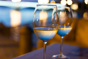 Two glasses of cold dry white wine served outdoor in cafe at night in historical Triana district, Sevilla, Spain, close up