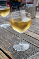 Tasting of Bordeaux white wine in Sauternes, left bank of Gironde Estuary, France. Glasses of white sweet French wine served in outdoor restaurant