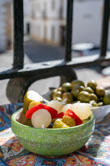 Spanish tapas, green andalusian olives with old Andalusian window bars and houses on background, Jerez de la Frontera, Andalusia, Spain