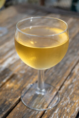 Tasting of Bordeaux white wine in Sauternes, left bank of Gironde Estuary, France. Glasses of white sweet French wine served in outdoor restaurant
