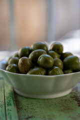 Spanish tapas, green andalusian olives with old Andalusian window bars and houses on background, Jerez de la Frontera, Andalusia, Spain