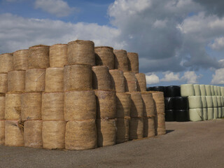 packed hay bales   against a cloudy sky