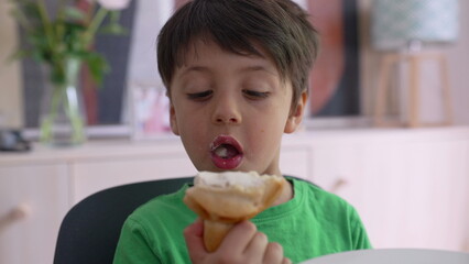 Young boy enjoying a snack, showing a playful and joyful expression. happiness of childhood during a relaxed time at home