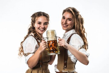 Two women dressed in traditional Bavarian clothing, each holding a beer mug