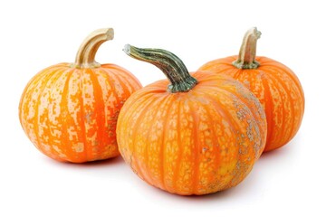 Fototapeta premium Three small orange pumpkins on a white surface