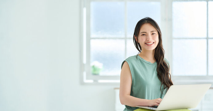 ノートパソコンで調べ物をする若い女性
