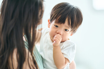 一歳の薄子を抱っこする若い母親