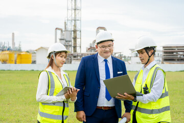 Asian managers and engineers inspect work in front of the company.